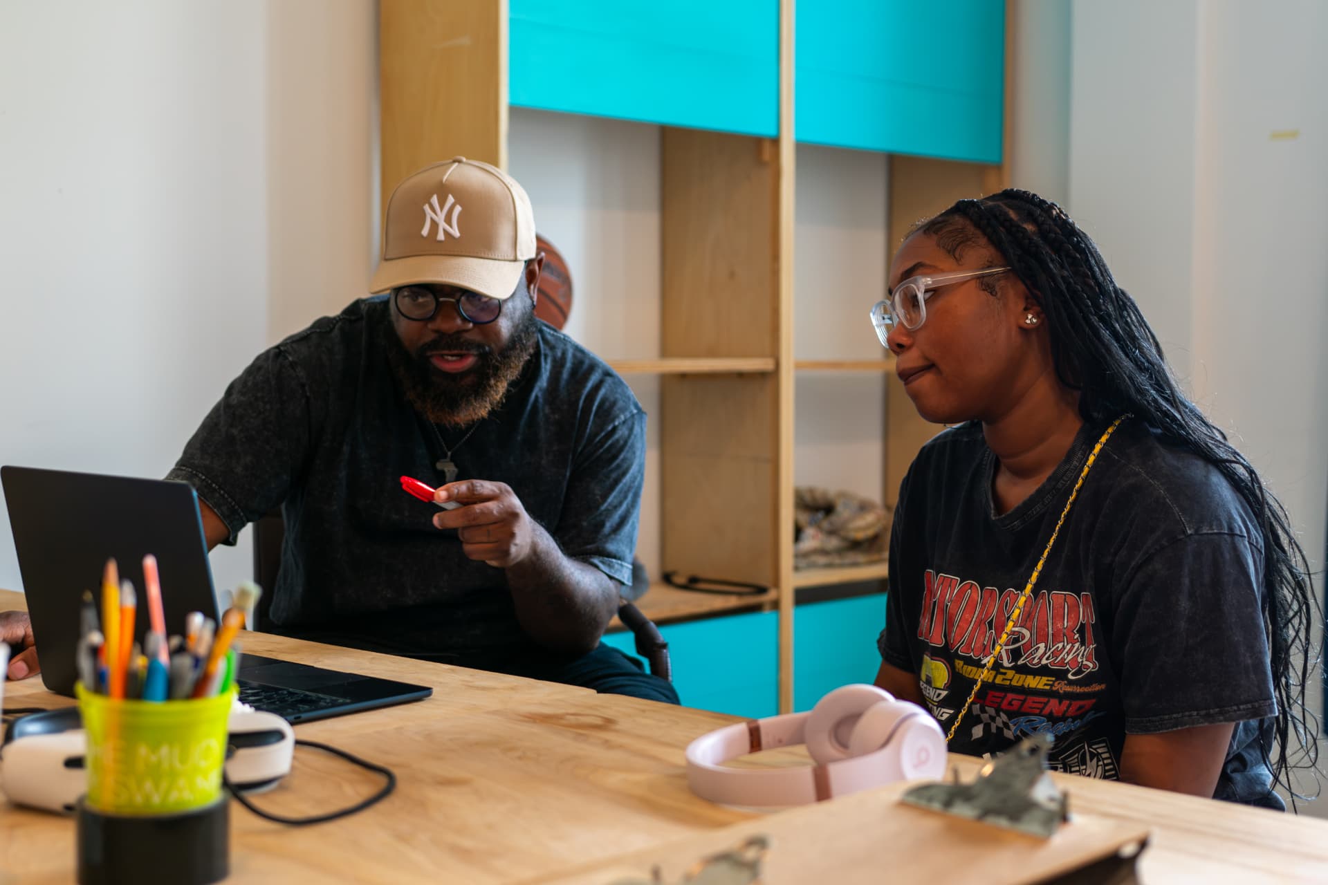A mentor and young producer reviewing work on a laptop