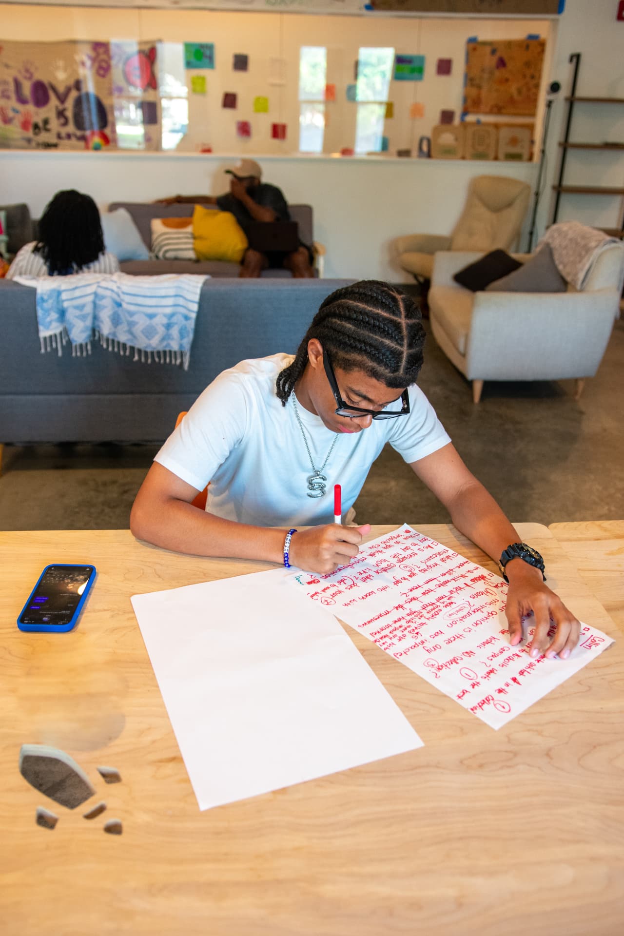 A young storyteller writing notes at a studio table