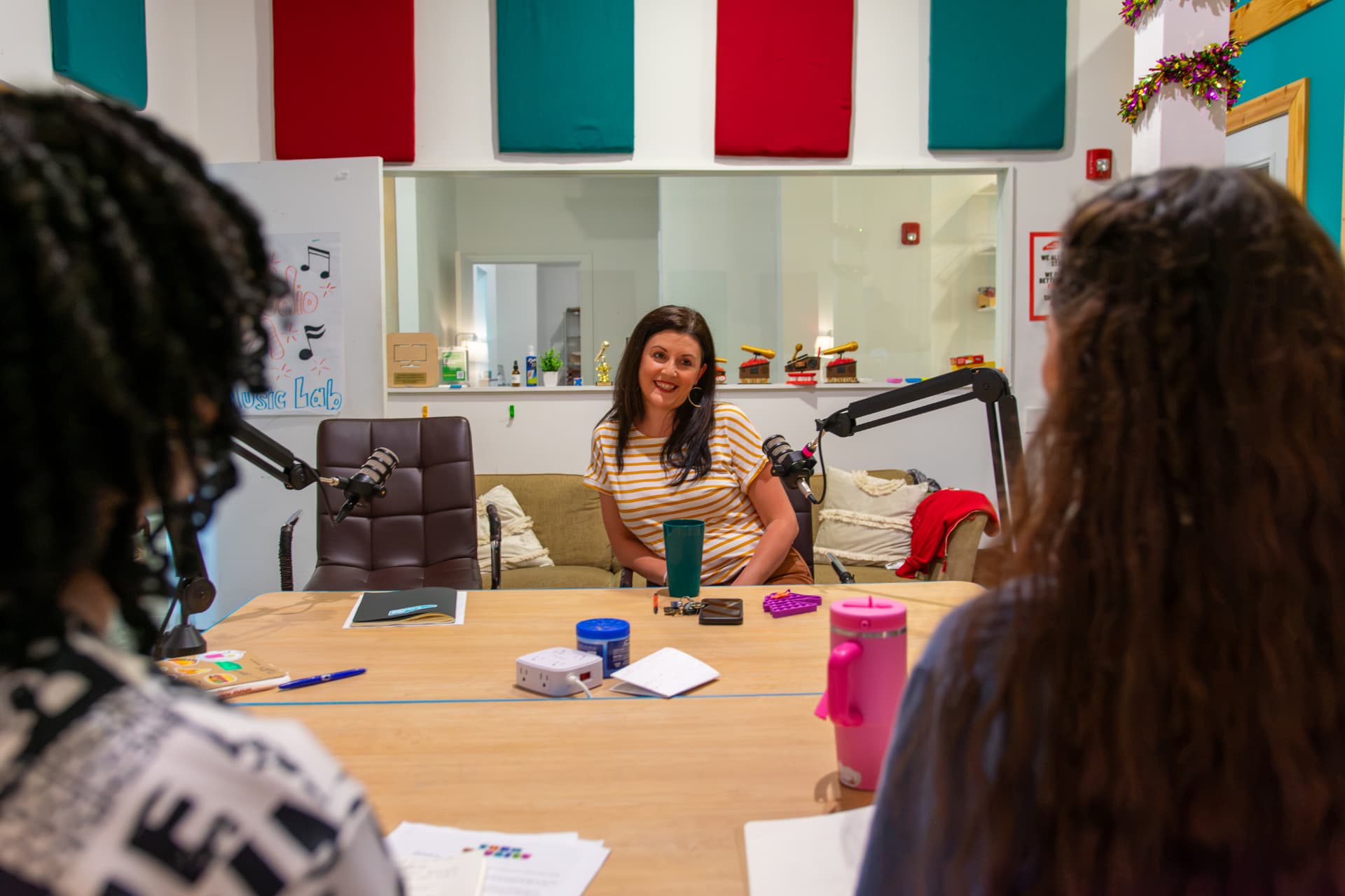 Young interviewers speaking with a guest at the microphones